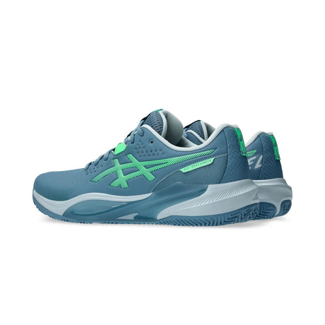 Blue athletic shoe with green accents on a white background