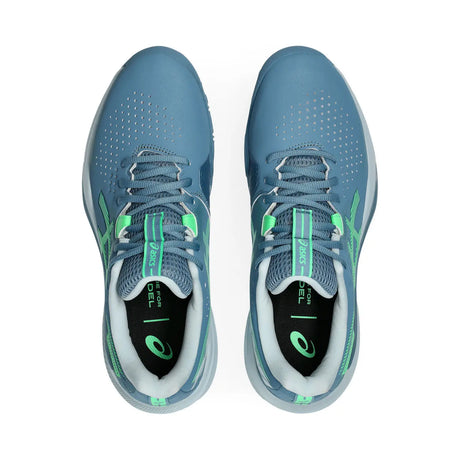 Pair of blue running shoes with green accents on a white background