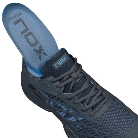 Navy athletic shoe with blue sole on a white background