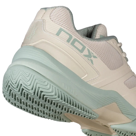 Beige and green sports shoe with 'NOX' branding on a white background