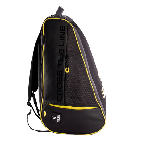 Black and yellow backpack with 'Cross the Line' branding on a white background