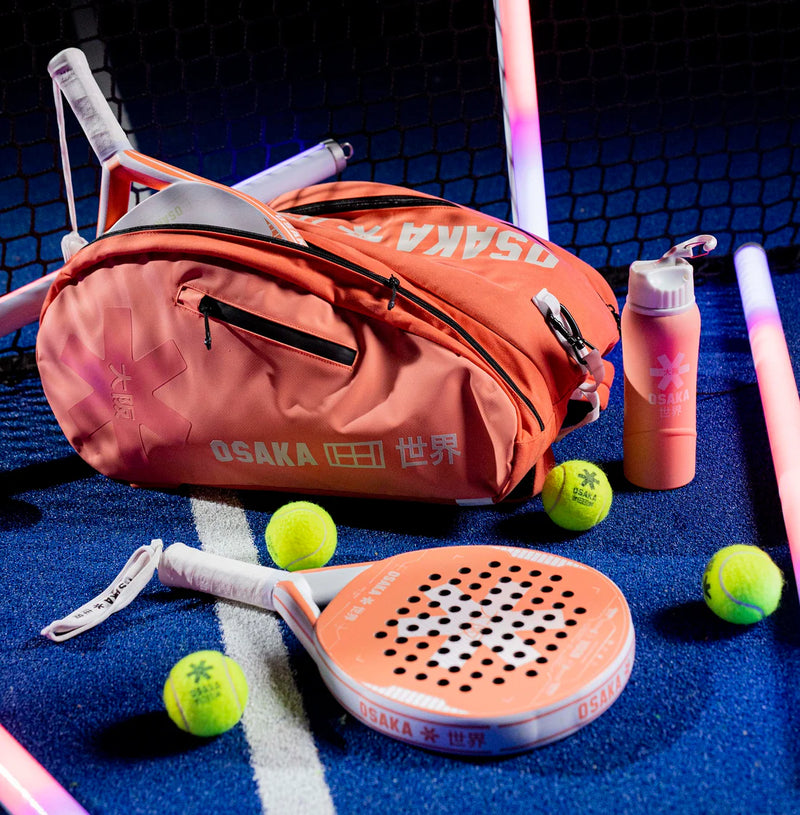 Paddle and ball set with Osaka branded equipment on a blue surface