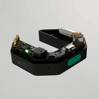 Black electronic device with green button on a gray background